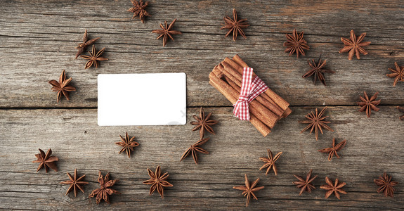 白商业访问卡和棕肉桂棒绑在灰木背景美味和香料的黑面包上顶视图片