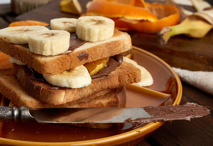 三明治加巧克力糊和香蕉片在盘子上早饭图片