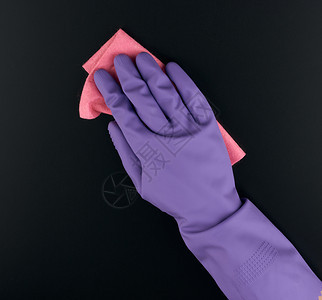手握着粉色抹布海绵清洁用手臂上戴着保护紫色橡胶手套紧闭图片