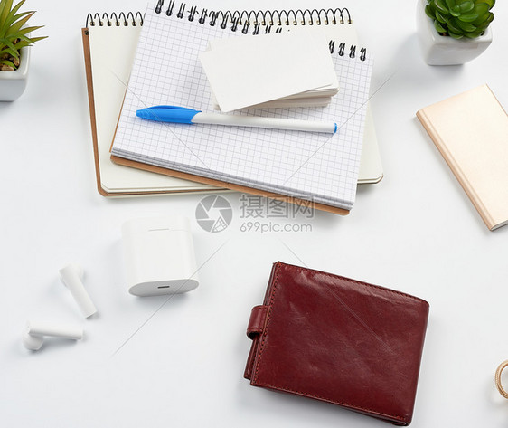 笔记本一叠名片棕皮钱包和电源库白桌工作场所顶视图片