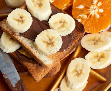 三明治加巧克力糊和香蕉片在盘子上早饭图片
