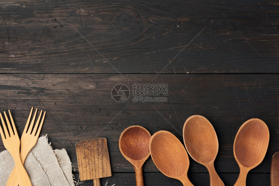木板顶视图厨房背景的棕色木上的空勺叉子和弹片图片