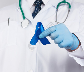 白制服医生和无菌乳胶手套戴深蓝丝带即及时研究和疾病预防结肠恶肿瘤慢疲劳综合症结核硬化的概念图片