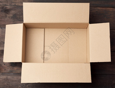 用于以棕色木背景顶视图运输货物的空棕色矩形纸板盒图片