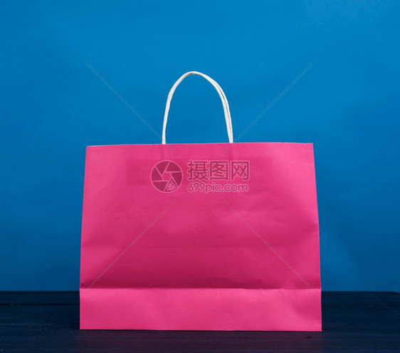 粉红色纸袋手柄购物和礼蓝色背景关闭图片