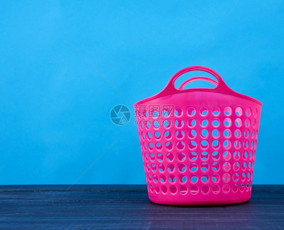 塑料粉色篮子在洞中放置清洁和脏衣服蓝底容器复制空间图片