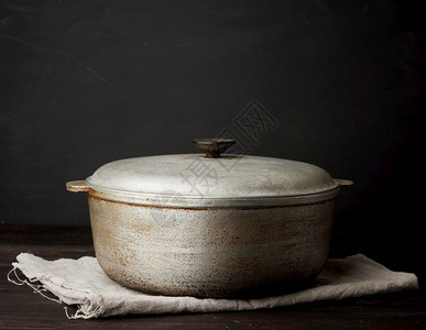 木制桌上的铝旧大锅厨房用具图片