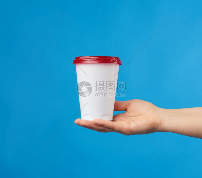 女手上握着一次白玻璃蓝色底有红帽喝着饮料图片