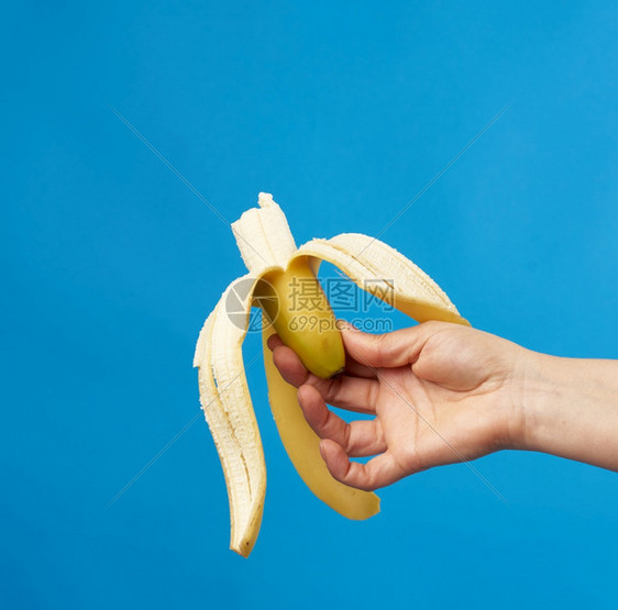 女用手握着蓝底的成熟香蕉皮紧闭图片