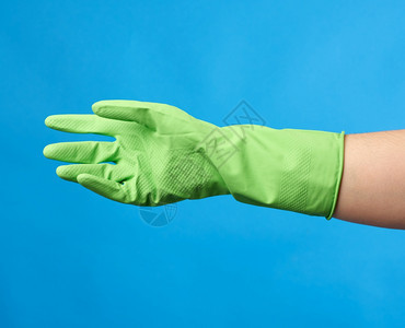 绿色橡胶手套用于清洗身着蓝底女手衣图片