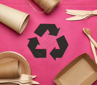 粉红色纸粉红色背景的棕手工艺纸上的可支配餐具以上视图塑料排斥概念零废物背景