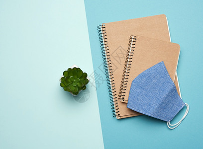 蓝背景的纸笔记本和蓝色可重复使用的面罩自制疾的治疗顶视生态友好概念零废物图片