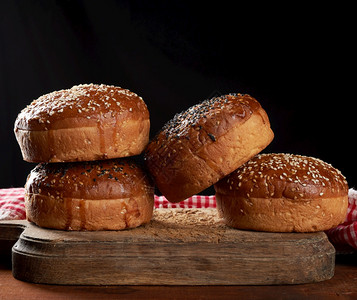 在棕色木板上做汉堡包烤芝麻面包关门图片