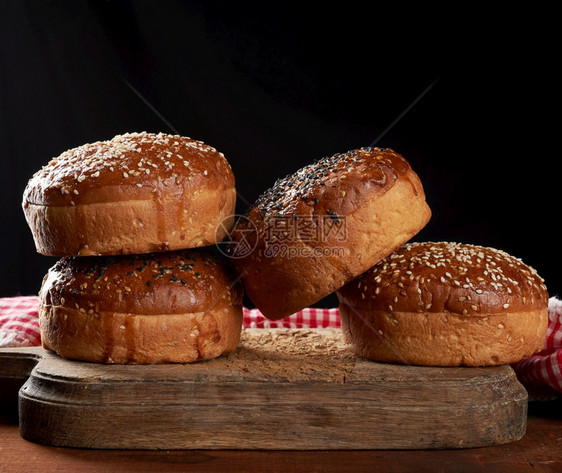 在棕色木板上做汉堡包烤芝麻面包关门图片