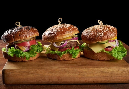 美味的汉堡包括炸牛肉切片番茄生菜和洋葱烤白面粉包和芝麻种子图片