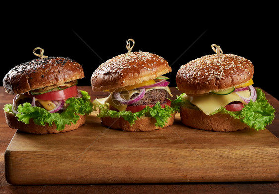 美味的汉堡包括炸牛肉切片番茄生菜和洋葱烤白面粉包和芝麻种子图片