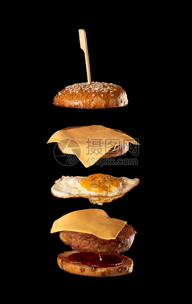 飞芝士汉堡成分肉片芝麻种子包士煎蛋和番茄酱黑色背景图片