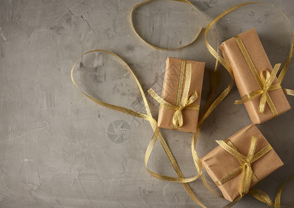以棕纸包裹的长方形盒子绑有丝带和弓礼物放在灰色背景顶视图复制空间图片