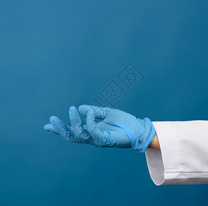 蓝底的色乳胶手套握物体图片