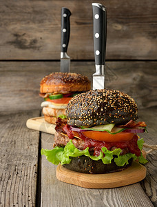带黑包肉和蔬菜的奶酪汉堡木本快餐和刀图片