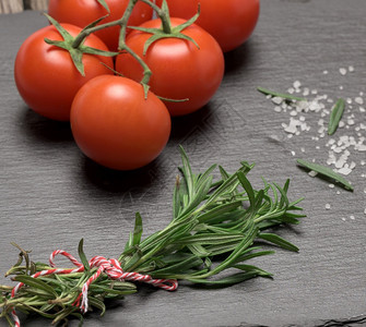 红番茄和新鲜的迷迭香调味品含黑色背景的绿叶香味调品图片