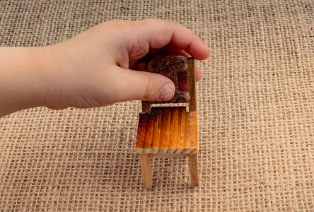 棕色木制玩具椅在帆布上的Hnad图片