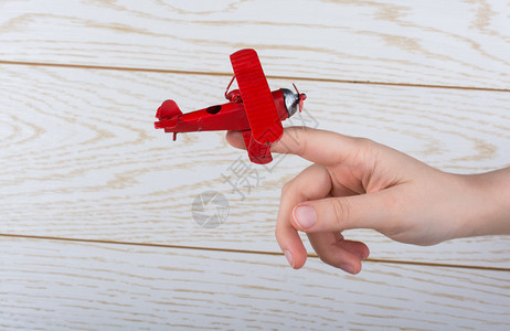 手持红色玩具飞机图片