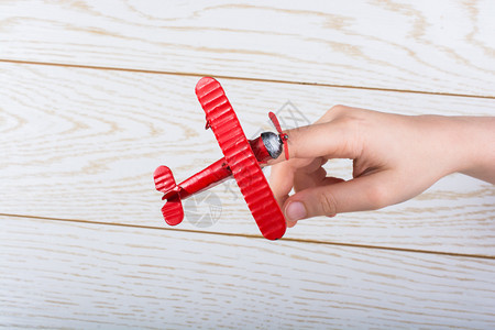 木板上的红色玩具飞机图片