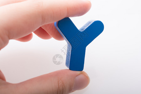 塑料玩具由木制成的手持字母立方Y背景