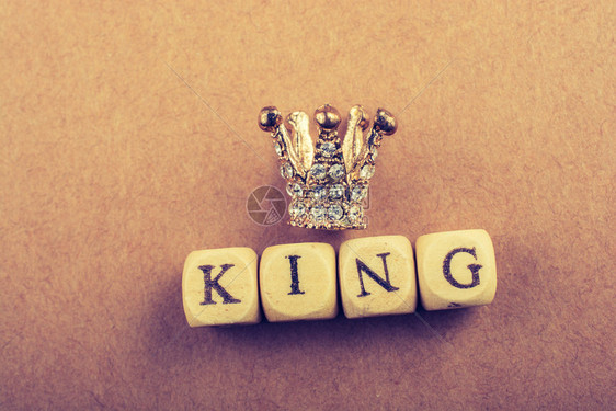 和国王在棕色上的措辞旁边微小模型王冠图片