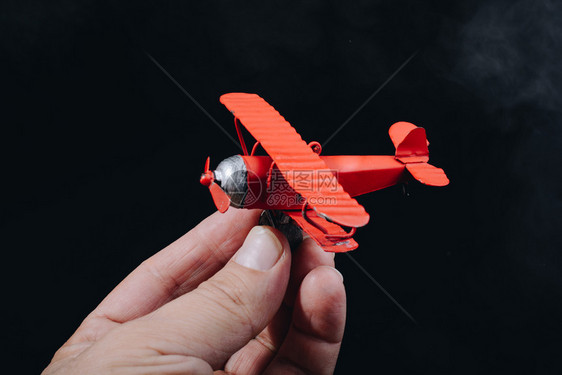 手持红色玩具飞机图片