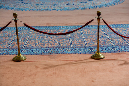 蓝色地毯旁显示的天鹅绒绳和金属架图片