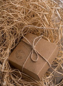 稻草填满背景上的棕色礼品盒图片