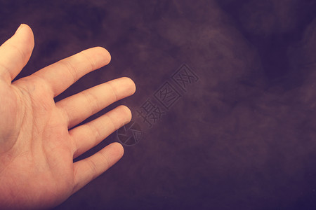 手在黑烟背景上做手势图片