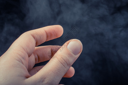 手在黑烟背景上做手势图片