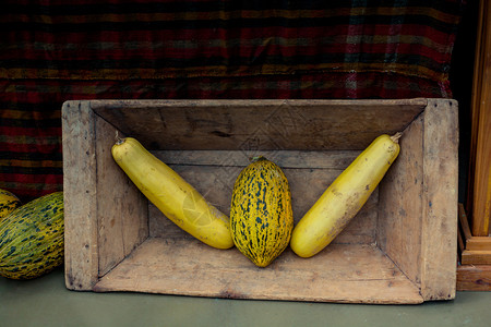 两个长的南瓜和一在个木盒子里在风景中图片