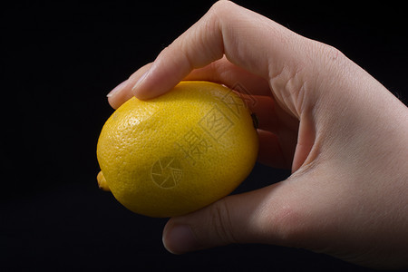 黄柠檬的果实在黑色手中图片