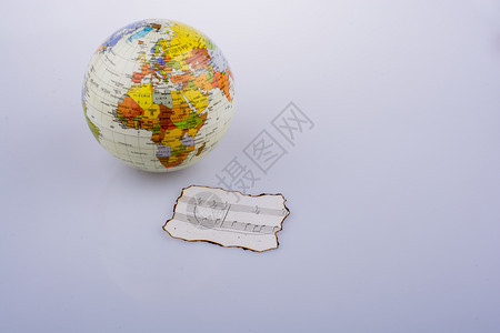 烧焦纸上的音乐笔记和一个小模样的地球背景图片