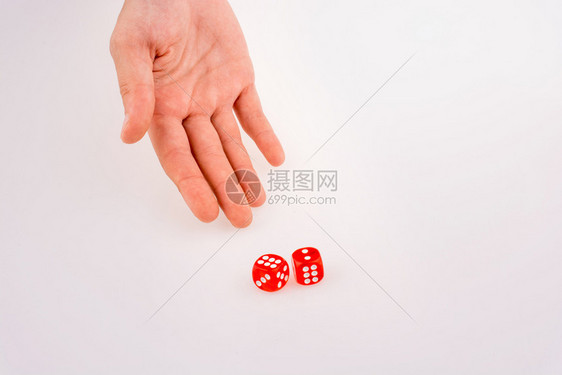 将红色骰子握在白背景上的手图片