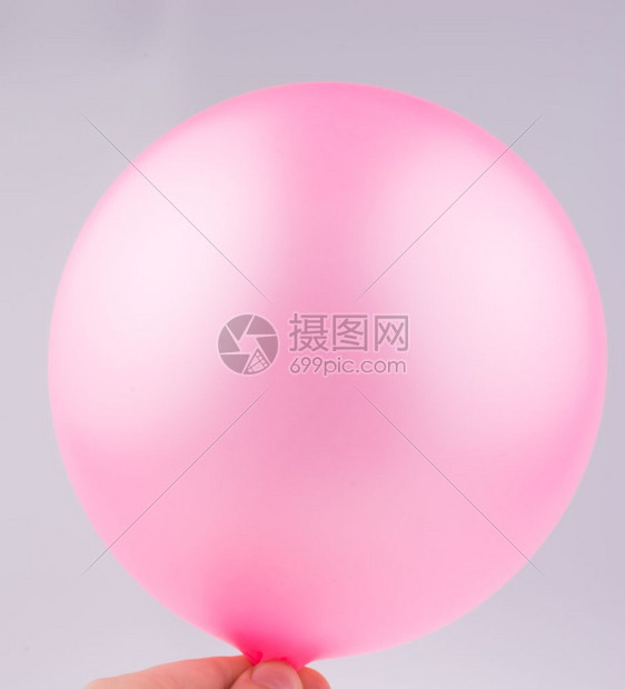 手握着粉红气球白色背景图片