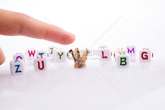 在白色背景的字母立方之间用手指向克朗图片