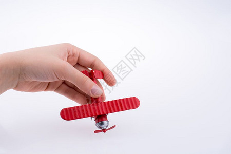 手持白色背景的红色玩具飞机图片