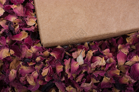 箱中和作为背景的干枯玫瑰花瓣图片