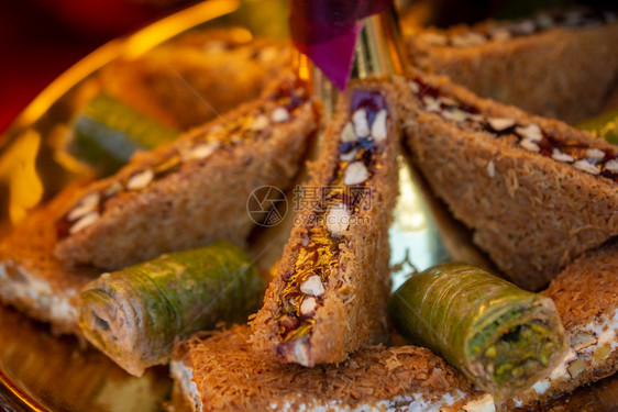 土耳其传统甜点Kadayif以糖浆烘烤配有坚果粉图片