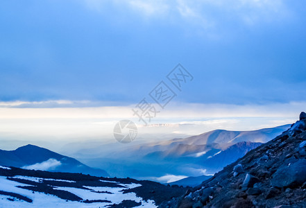 雪山山顶上云层的景色和蓝色的天空背景图片