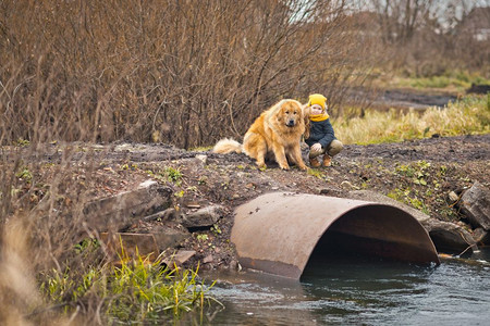 小孩吓着大狗看河水小孩和狗在大坝上巨的水管9780图片