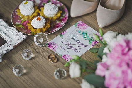 新婚夫妇在餐桌上的金环在鲜花鞋和之间图片