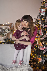 妈在圣诞树960的背面拥抱着女儿背景图片