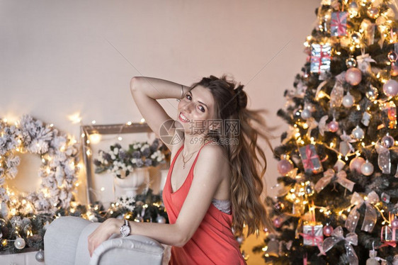 在圣诞节装饰中长发的女孩美丽肖像在基督背景上流着头发图片