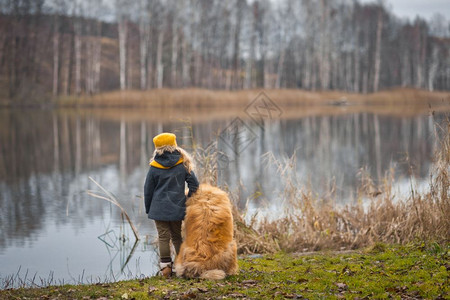 在湖边做梦的小女士和她狗带着女孩看一个9805秋季湖的表面图片